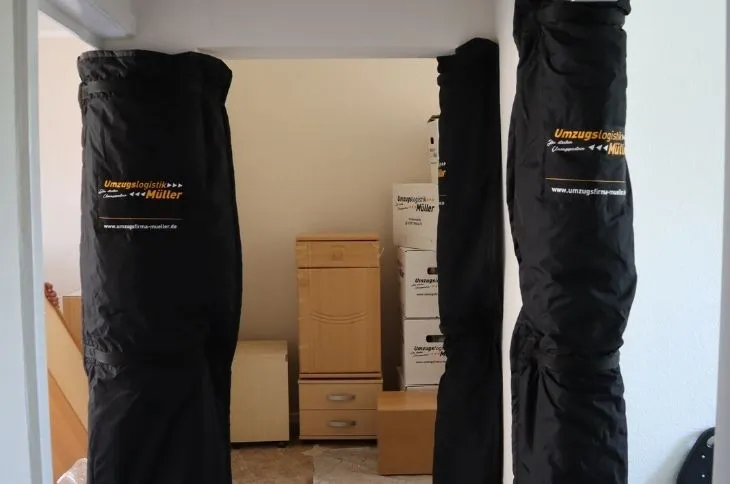 umzugshelfer transportieren eingewickelte moebel im innenraum